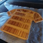 Een custom made borrelplank met ontwerp van voetbalshirt van de Graafschap, gemaakt van Bamboe